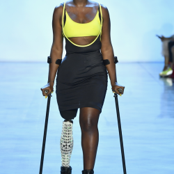 Mama Cax walks the runway using crutches as her right leg was amputated