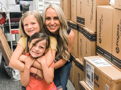 woman holding her children with boxes around them