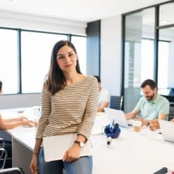 confident businesswoman with laptop at desk in office