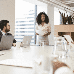 profeesional woman speaking to staff in a conference room