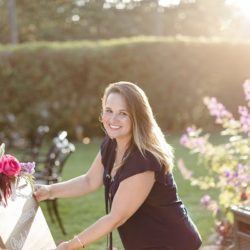 Amy Grace decorating for an outdoor wedding while looking at the camera