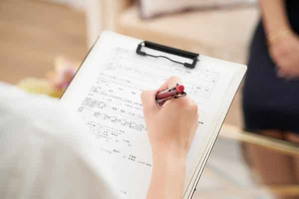 woman sitting at table filling out a medical form