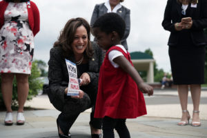 Kamala Harris with a girl in a red dress