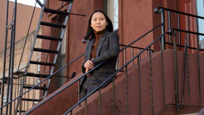 Asian woman standing on stairs wearing a grey suit