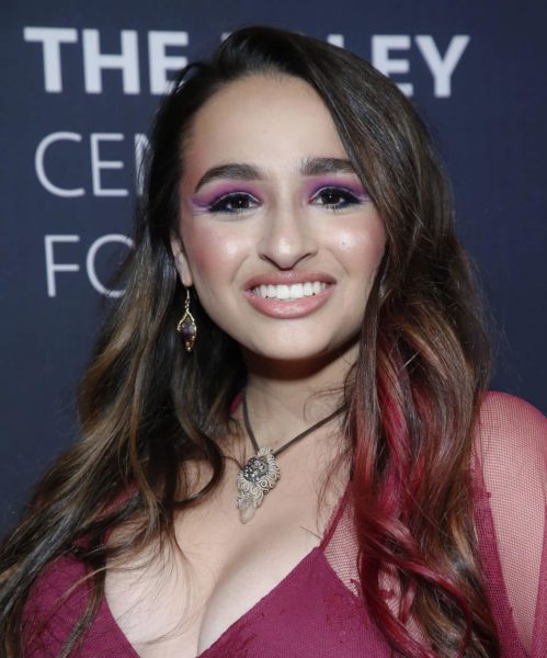 Jazz Jennings smiling while wearing a hot pink tank top dress