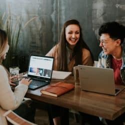 three women working together on laptops together