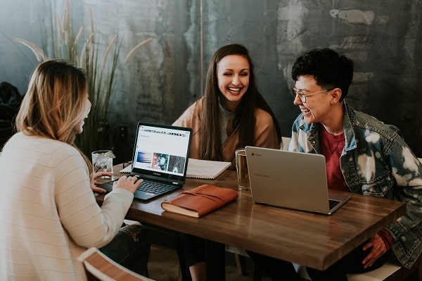 three women working together on laptops together