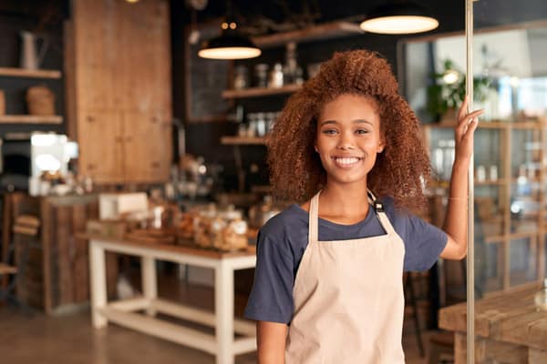 attractive young woman standing in front of a cafe
