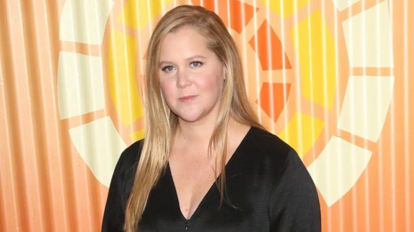 Amy Schumer wearing a black top while smiling at the camera