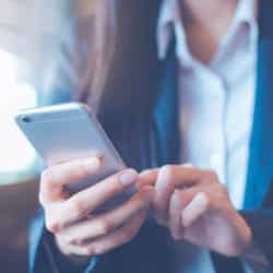 women hand are using cell phone to text