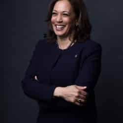 Vice president Kamala harris smiling away from the camera while wearing a pantsuit.