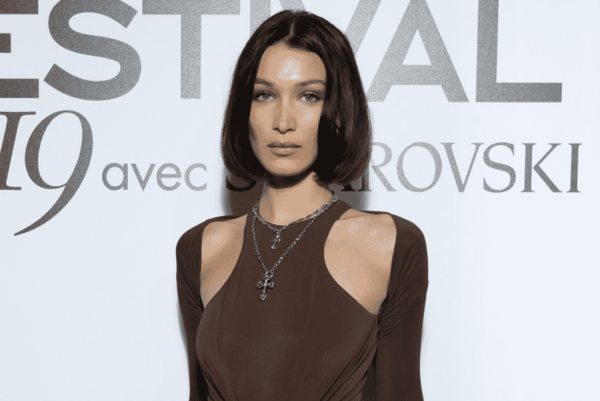 Bella Hadid wearing a brown tank top and a brown cardigan posing for the paparazzi