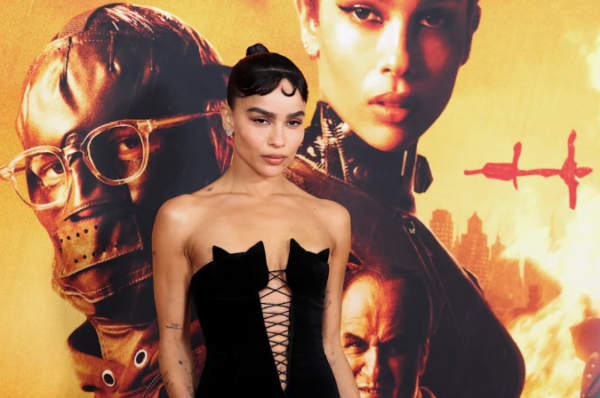 Zoë Kravitz on the red carpet for her role as catwoman. She is wearing an all black tube top with kittens shaping the top