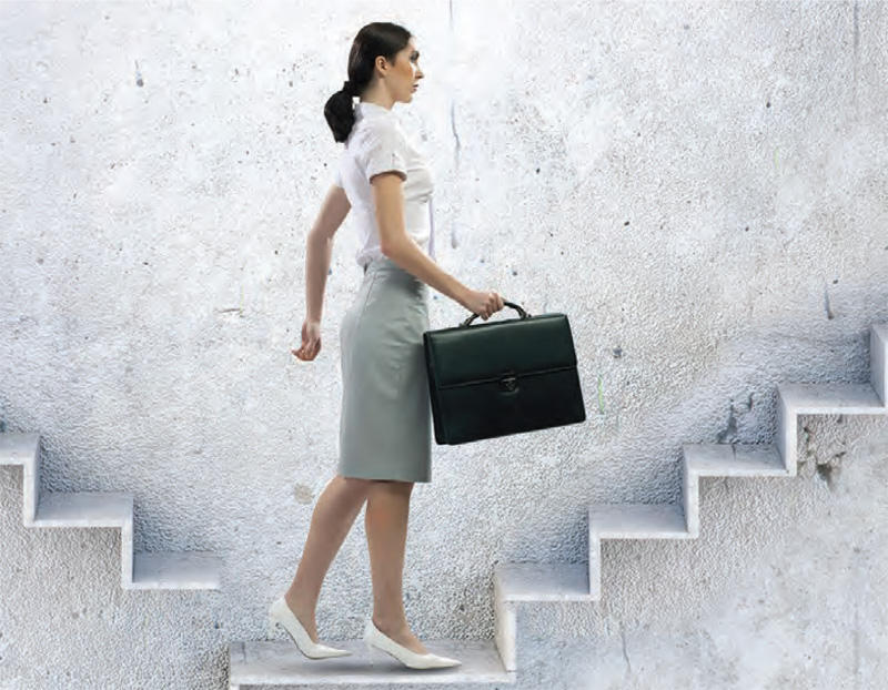 woman with briefcase climbing flight of stairs