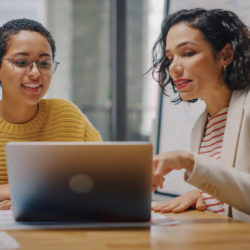two females looking at a laptop screen together
