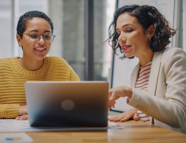 two females looking at a laptop screen together