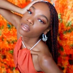 Pierrah Hilaire wearing orange for her article On Going Viral Teaching Her TikTok Followers About Black Fashion Brands
