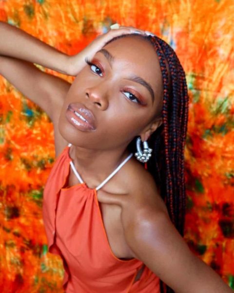 Pierrah Hilaire wearing orange for her article On Going Viral Teaching Her TikTok Followers About Black Fashion Brands