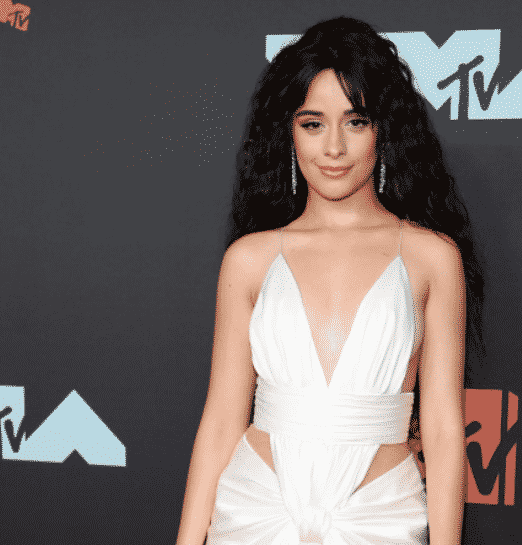 Camila Cabello wearing a white dress on the red carpet