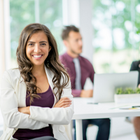 female execs smiling at camera with employee in background