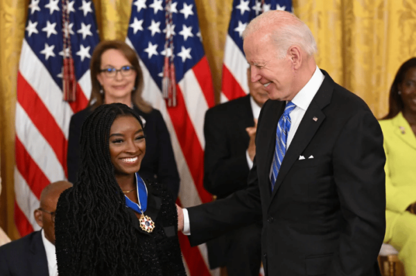 Joe Biden putting the Presidential Medal of Freedom award on Simone Biles