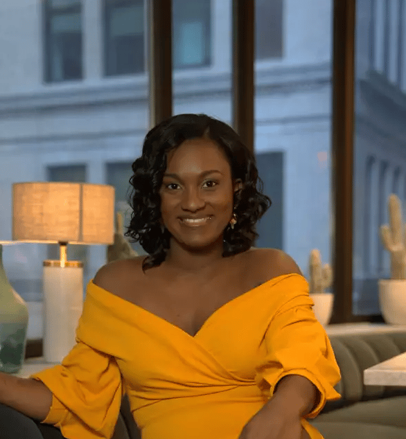 Beverly Malbranche wearing a yellow shirt and smiling at the camera