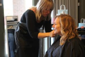 a Woman getting her hair cut by another woman