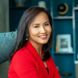 Ying McGuire smiling wearing red blazer