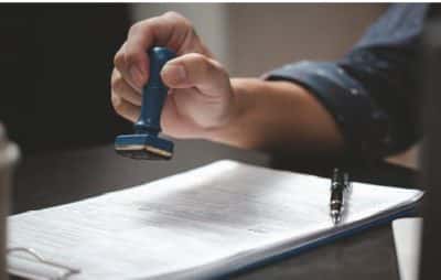 man with rubber stamp and documents