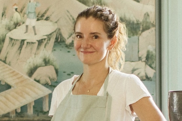 Elena Reygadas smiling with a green floral background