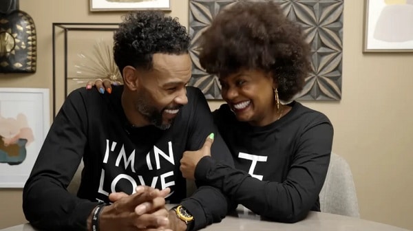 Tabitha Brown and husband wearing matching sweatshirts smiling